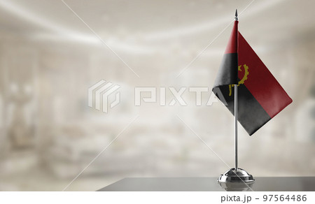 A small Angola flag on an abstract blurry background 97564486