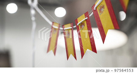 A garland of Spain national flags on an abstract blurred background 97564553