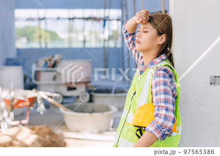 woman worker tired from work hard overwork fatigue be sick at construction site 97565386