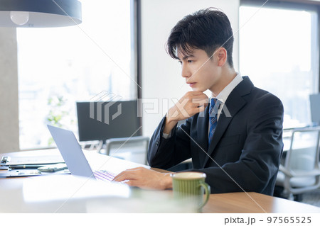 オフィスでスーツでパソコン作業をする若い男性 97565525