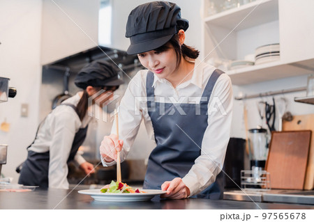 レストランのキッチンで働く2人の女性スタッフ 97565678