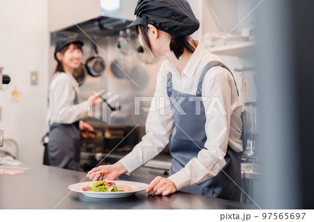 レストランのキッチンで働く2人の女性スタッフ レストランのキッチンで働く2人の女性スタッフ 97565697