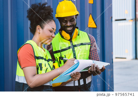 African American couple customs team staff worker working together with check list shipping order at port container yard enjoy work happy smile 97565741