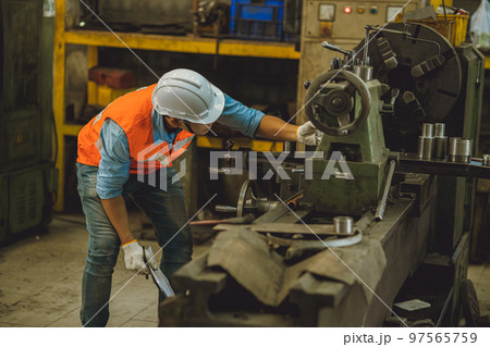 Industry male engineer worker safety check machine service fix setup working in lathe steel metal factory Industry male engineer worker safety check machine service fix setup working in lathe steel metal factory 97565759