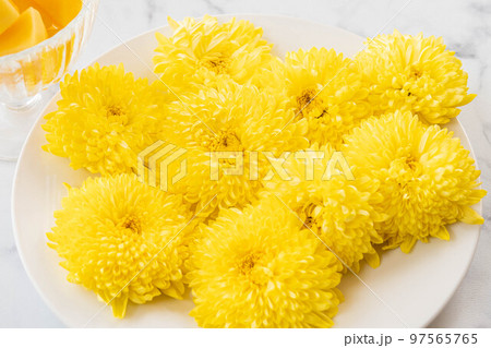 白い皿の上の黄色い菊の花 97565765
