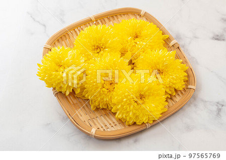 笊の上の黄色い菊の花 97565769