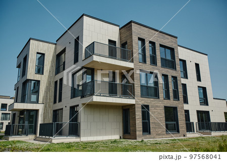 Modern apartment building in housing complex lit by sunlight 97568041
