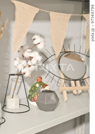 natural eco home decor on a shelf. cotton buds, concrete vase and eye shaped mirror on wooden stand. cotton bunting in beige unbleached color 97568799