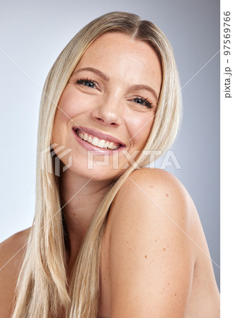 Face portrait, skincare and makeup of woman in studio isolated on a gray background. Natural beauty, aesthetics and cosmetics of female model with long blonde hair after salon treatment for growth. 97569766
