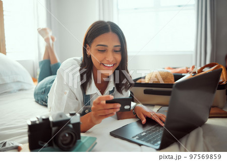 Ecommerce, travel and credit card of a woman packing suitcase with computer booking flight in hotel. Internet, online shopping and digital banking of a person on a bed ready for a vacation discount 97569859