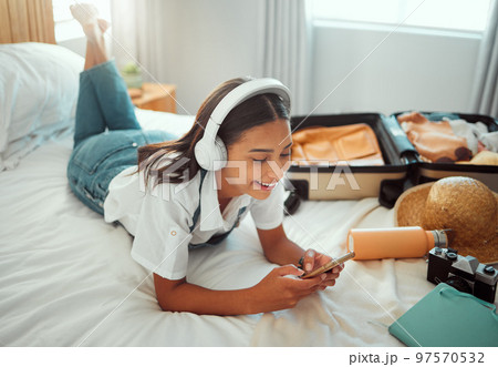 Social media, music and woman with phone on a holiday, travel communication and mobile app update. Podcast, internet and girl in a bedroom for freedom on vacation, streaming radio and typing on chat 97570532