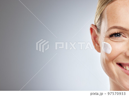 Skincare, half face and portrait of woman with beauty, cosmetic and natural facial treatment in studio. Girl model with face cream, spf or lotion for skin routine by gray background with mockup space Skincare, half face and portrait of woman with beauty, cosmetic and natural facial treatment in studio. Girl model with face cream, spf or lotion for skin routine by gray background with mockup space 97570933