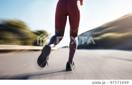 Motion blur, woman and legs running on road for exercise, marathon workout and sports training. Back view, closeup and runner athlete with fast energy, fitness health and performance power outdoors Motion blur, woman and legs running on road for exercise, marathon workout and sports training. Back view, closeup and runner athlete with fast energy, fitness health and performance power outdoors 97571049