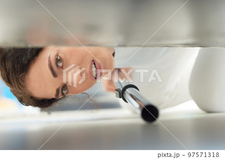 Cleaning, vacuum and face of woman under sofa for housework or hygiene. Spring cleaning, machine and portrait of female cleaner vacuuming floor to remove dust or dirt in home living room or lounge. Cleaning, vacuum and face of woman under sofa for housework or hygiene. Spring cleaning, machine and portrait of female cleaner vacuuming floor to remove dust or dirt in home living room or lounge. 97571318