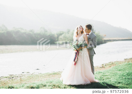 Beautiful wedding couple, love on the sunset. Fielf with flowers 97572036