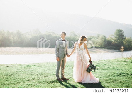 Beautiful wedding couple, love on the sunset. Fielf with flowers 97572037