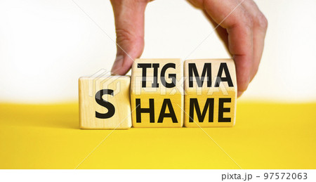 Stigma or shame symbol. Concept words Stigma or Shame on wooden cubes. Businessman hand. Beautiful yellow table white background. Business stigma or shame concept. Copy space. 97572063