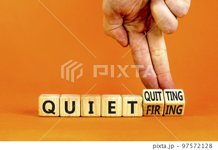 Quiet quitting or firing symbol. Concept words Quiet quitting Quiet firing on cubes. Businessman hand. Beautiful orange table orange background. Business quiet quitting or firing concept. Copy space. 97572128
