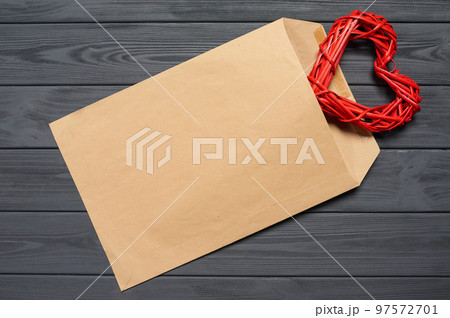 Blank envelope on wooden plank table with heart shape Blank envelope on wooden plank table with heart shape 97572701