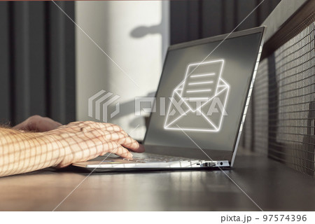 Spam email. Man receiving junk mail, unwanted messages, ads for money scams while working on laptop. Hands on keyboard closeup 97574396