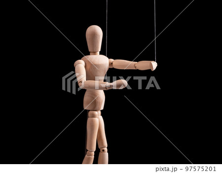 Puppet on strings. Manipulation, control, power, abuse concept. Marionette in human hand. Puppet on strings. Manipulation, control, power, abuse concept. Marionette in human hand. 97575201