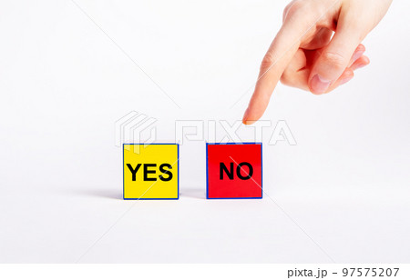 Choice between positive and negative decisions concept. Forefinger pointing to red cube with no text instead of yellow one with yes word. Rejection, disapproval or wrong answer concept 97575207