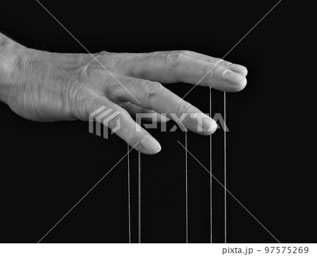 Influence, manipulation concept. Man hand with strings on fingers. Master, abuser using power to control person behavior. Black and white Influence, manipulation concept. Man hand with strings on fingers. Master, abuser using power to control person behavior. Black and white 97575269