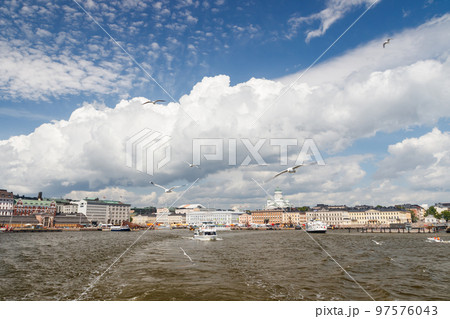 Helsinki, Finland, panorama of the Market Square Kauppatori in the port of Helsinki. Seagulls flying over water. View from sea. Helsinki, Finland, panorama of the Market Square Kauppatori in the port of Helsinki. Seagulls flying over water. View from sea. 97576043