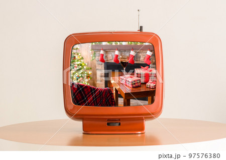 Tv showing movie of Armchair with plaid, packing gift boxes for family and glass of wine near christmas tree and fireplace. Top view . 97576380
