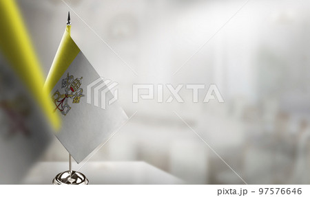 Small flags of the Vatican on an abstract blurry background 97576646