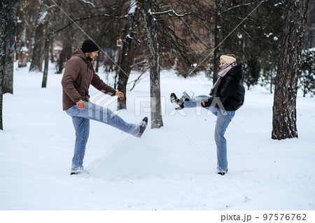 Valentines day outdoors celebration date ideas. Winter love story. Cold season dating for couples. Young couple in love play snowball, hugging and kissing in winter city street and park Valentines day outdoors celebration date ideas. Winter love story. Cold season dating for couples. Young couple in love play snowball, hugging and kissing in winter city street and park 97576762