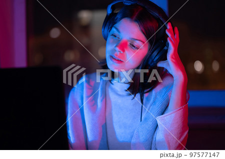 Girl is listening music at home at night. Girl is listening music at home at night. 97577147