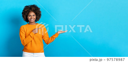 Positive african american young woman showing empty space Positive african american young woman showing empty space 97578987