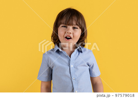 Wow great. Close up portrait of adorable excited little boy smiling to camera, enjoying what he sees, orange background 97579018
