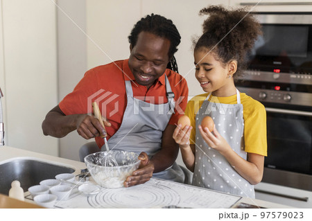 Cheerful African American Dad And Daughter Cooking Together In Kitchen 97579023