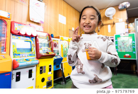 駄菓子屋さんで遊ぶ小学生 97579769