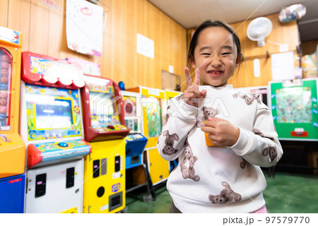 駄菓子屋さんで遊ぶ小学生 97579770