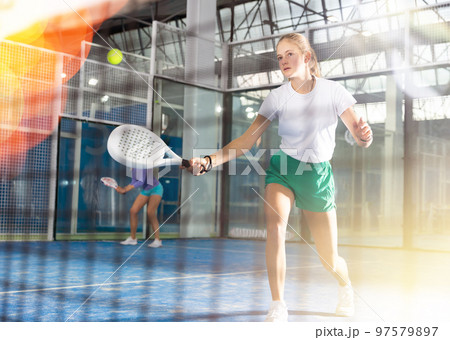 Young girl with racquet playing padel 97579897