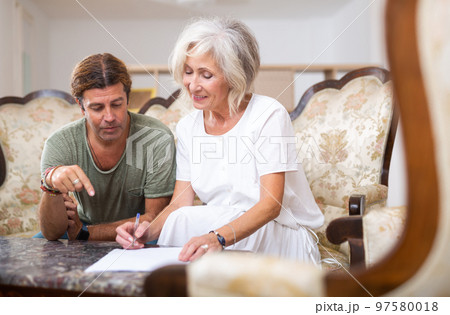 Mature woman and man doing paperwork together 97580018