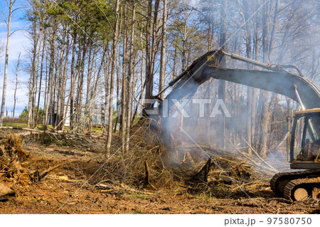 Uprooting of trees in order to build houses in housing complex which is posing an ecological disaster, there is need to clear land order to burn these trees. 97580750
