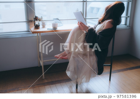 部屋で読書をする若い女性の写真 部屋で読書をする若い女性の写真 97581396