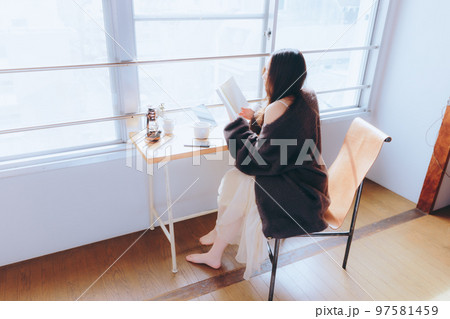 部屋で読書をする若い女性の写真 部屋で読書をする若い女性の写真 97581459