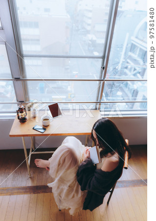 部屋で読書をする若い女性の写真 97581480