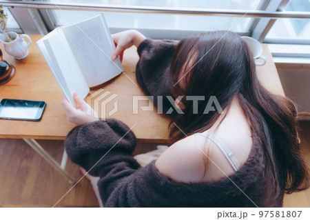 部屋で読書をする若い女性の写真 97581807