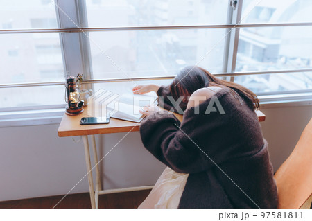 部屋で読書をする若い女性の写真 97581811