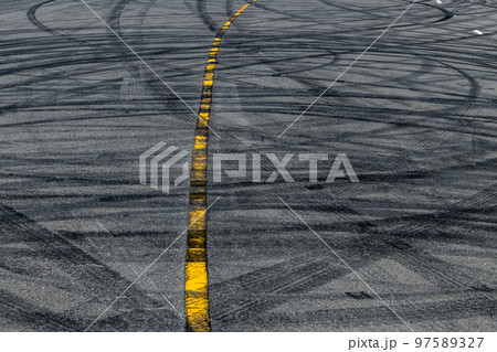 Tire track mark on asphalt tarmac road race track texture and background, Abstract background black tire tracks skid on asphalt road in racing circuit, Tire mark skid mark on asphalt road. 97589327