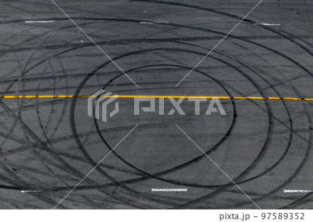 Tire track mark on asphalt tarmac road race track texture and background, Abstract background black tire tracks skid on asphalt road in racing circuit, Tire mark skid mark on asphalt road. 97589352