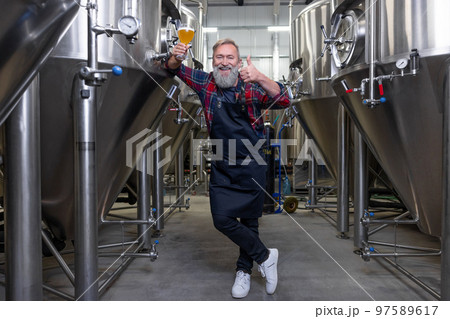 Brewery owner demostrating his product and looking proud 97589617