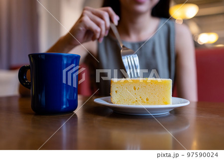 Woman enjoy her cake in coffee shop 97590024