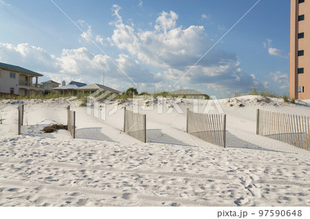 Destin, Florida- Wood fence panels in a row on a beach white sand against the sky Destin, Florida- Wood fence panels in a row on a beach white sand against the sky 97590648
